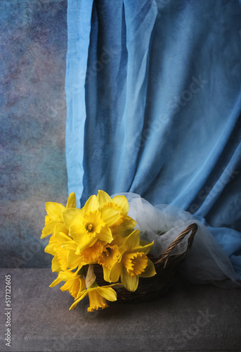 Still life with yellow daffodils on a blue background, the colors of the Ukrainian flag