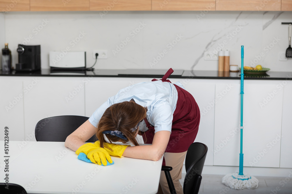 Tired woman fall asleep on white table while wiping cleaning the living ...