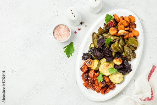 Healthy meal roasted vegetables on white dish. Top view, flat lay, copy space.
