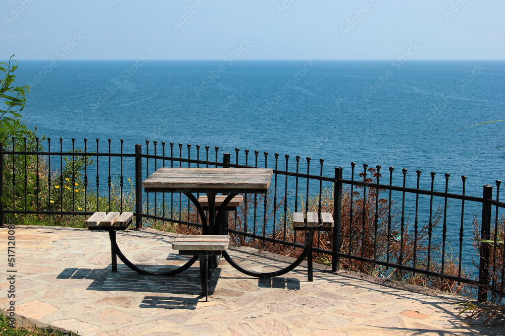 Empty table with four seats in a seaside park