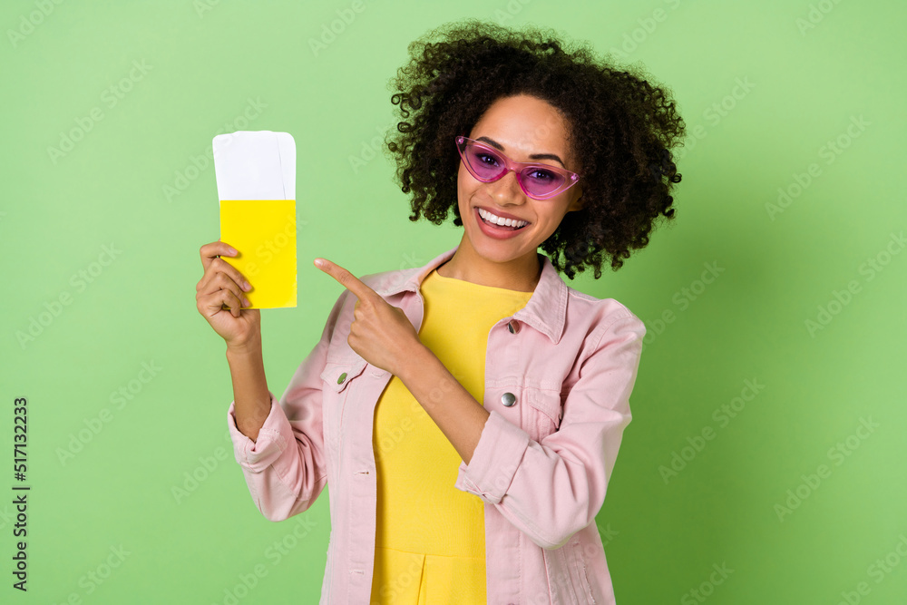 Portrait of attractive cheerful girl indicate finger flight tickets passport isolated on green color background Portrait of attractive cheerful girl indicate finger flight tickets passport isolated on green color background