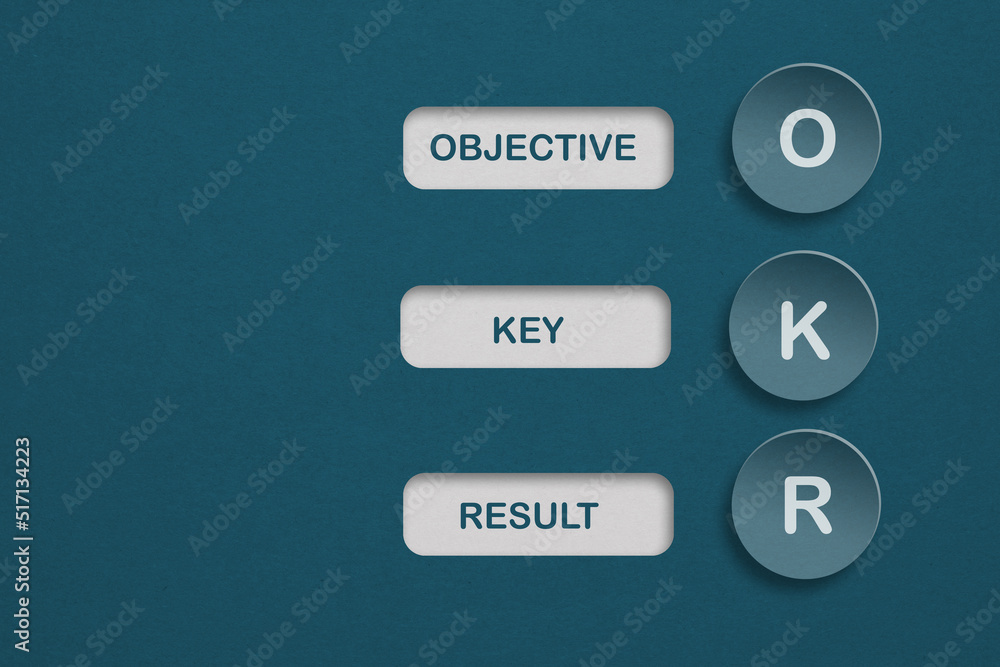 OKR text (Objectives, Key and Results) on circle blue paper cut and grunge blue paper texture background with copy space for business target and focus concepts OKR text (Objectives, Key and Results) on circle blue paper cut and grunge blue paper texture background with copy space for business target and focus concepts