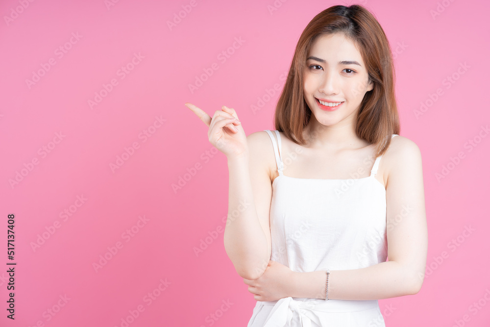 Image of young Asian woman posing on pink background Image of young Asian woman posing on pink background