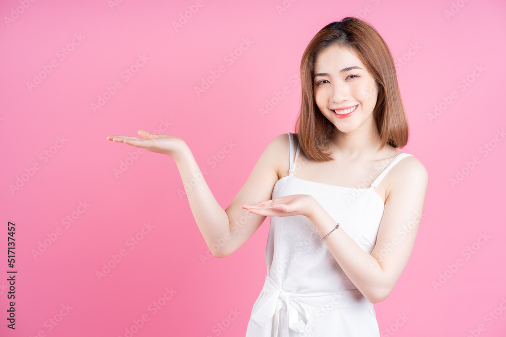 Image of young Asian woman posing on pink background Image of young Asian woman posing on pink background