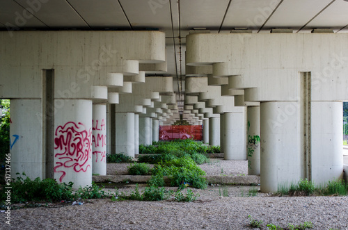 I piloni di un viadotto autostradale con dei graffiti creano una prospettiva urbana photo