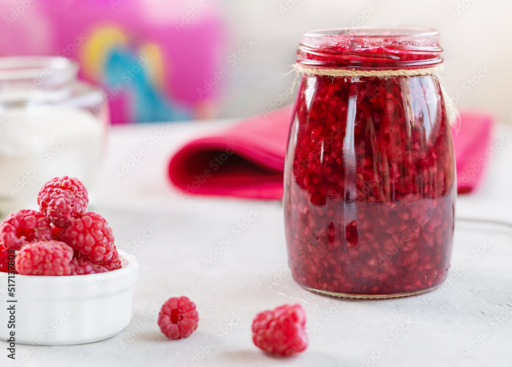 Fresh raspberries jam in a jar and berries on a light background. Good for a healthy breakfast. Fresh raspberries jam in a jar and berries on a light background. Good for a healthy breakfast.