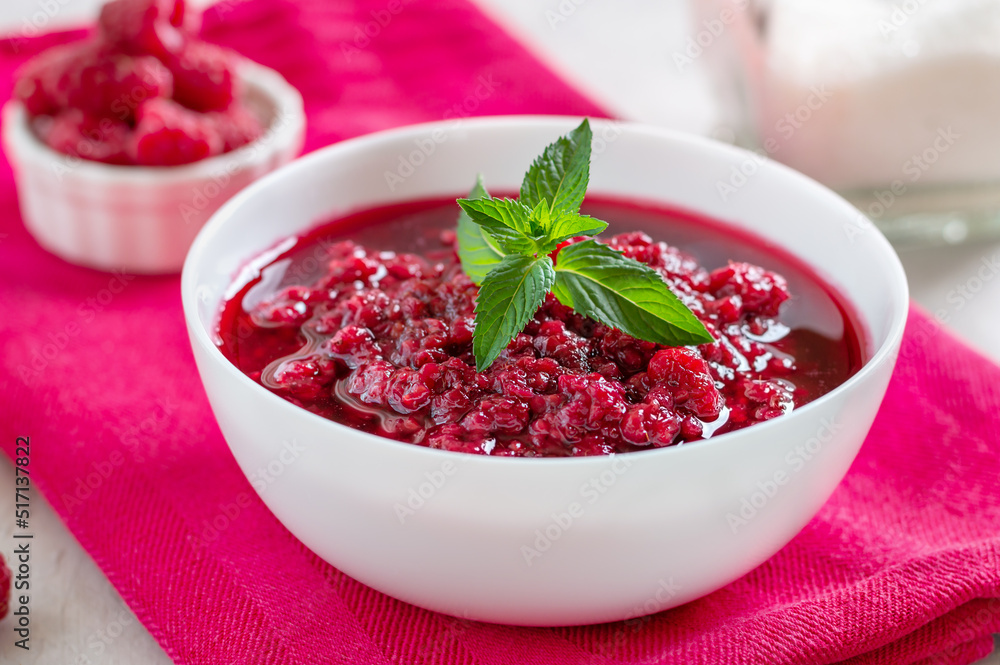 Freshly prepared raspberry jam in a white bowl on a pink napkin, close-up Freshly prepared raspberry jam in a white bowl on a pink napkin, close-up