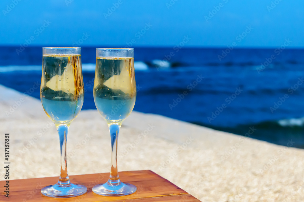 Two champagne glasses against a sea in the evening. Copy space Two champagne glasses against a sea in the evening. Copy space