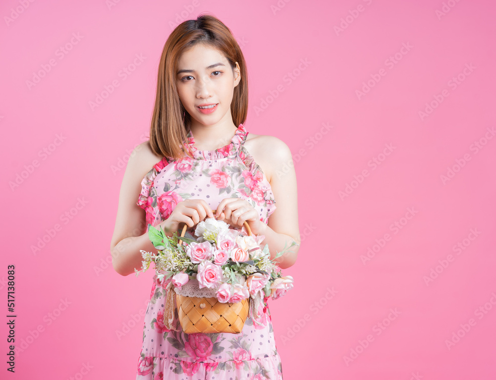 Photo of young Asian girl wearing flower dress on pink background Photo of young Asian girl wearing flower dress on pink background