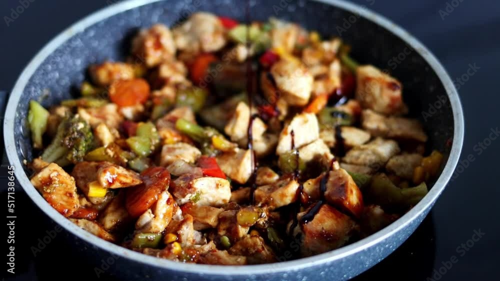 The chef pours sauce on vegetables with meat that is stewed in a pan. Cooking in a restaurant's kitchen. Slow-motion The chef pours sauce on vegetables with meat that is stewed in a pan. Cooking in a restaurant's kitchen. Slow-motion