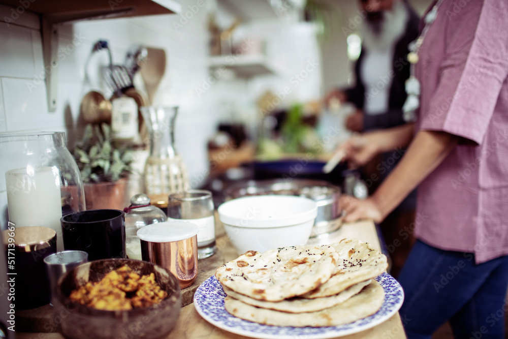 Woman making flatbread at kitchen stove
