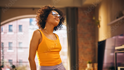 Portrait of Multiethnic Young Black Female Dancing in Comfy Casual Clothes, Having Fun at Home in Loft Apartment. Recording Funny Viral Videos for Social Media. Close Up Shot. © Gorodenkoff