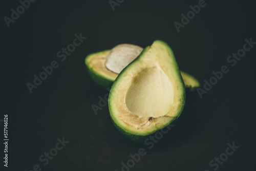 Ripe avocado halves on a dark background.
