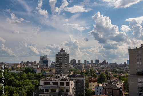 Beautiful rooftop view of Belgrade city residential area architecture and main street with white fluffy clouds. Belgrade, Serbia 09.06.2022