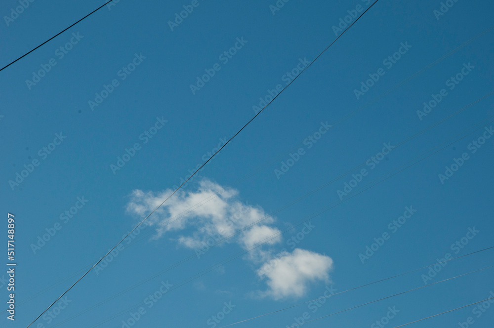 Wires in cloudy blue sky background, copy space