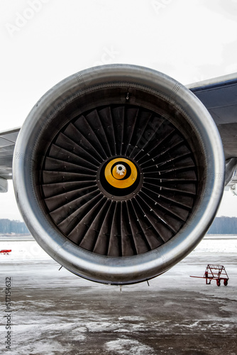 Airplane engine with aircraft wing on runway of airfield