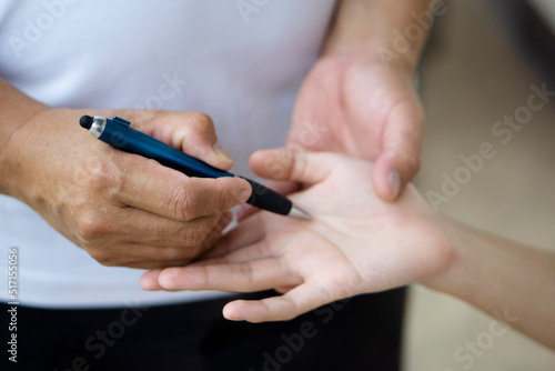 Fortune teller s hand holds pen to check palm line of client .Concept   palmistry  astrology. Foretelling  mystery  magic  fortune  fate. Prediction for future life  events.  Palmist predicting. 