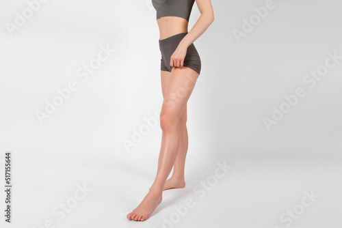 Perfect body shape close up on white background. Great figure of a tanned woman. Parts of a female body in underwear studio shot. Sportswear and yoga wear. Healthy lifestyle, skin, waist abs athletic.