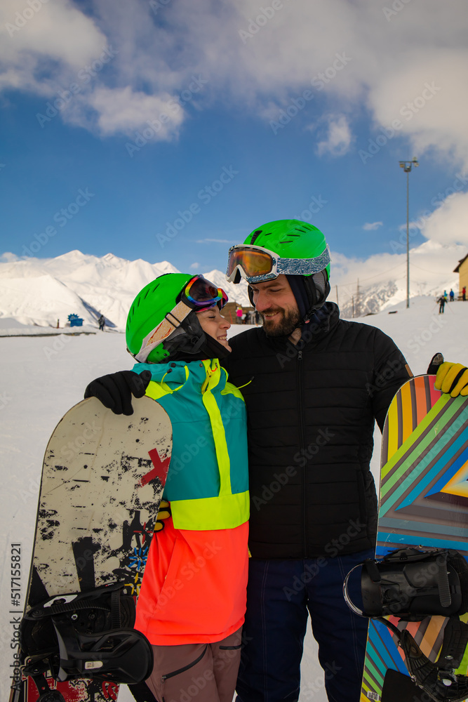 Ski and snowboard. Cool male and female snowboarders on Alps in winter holidays.