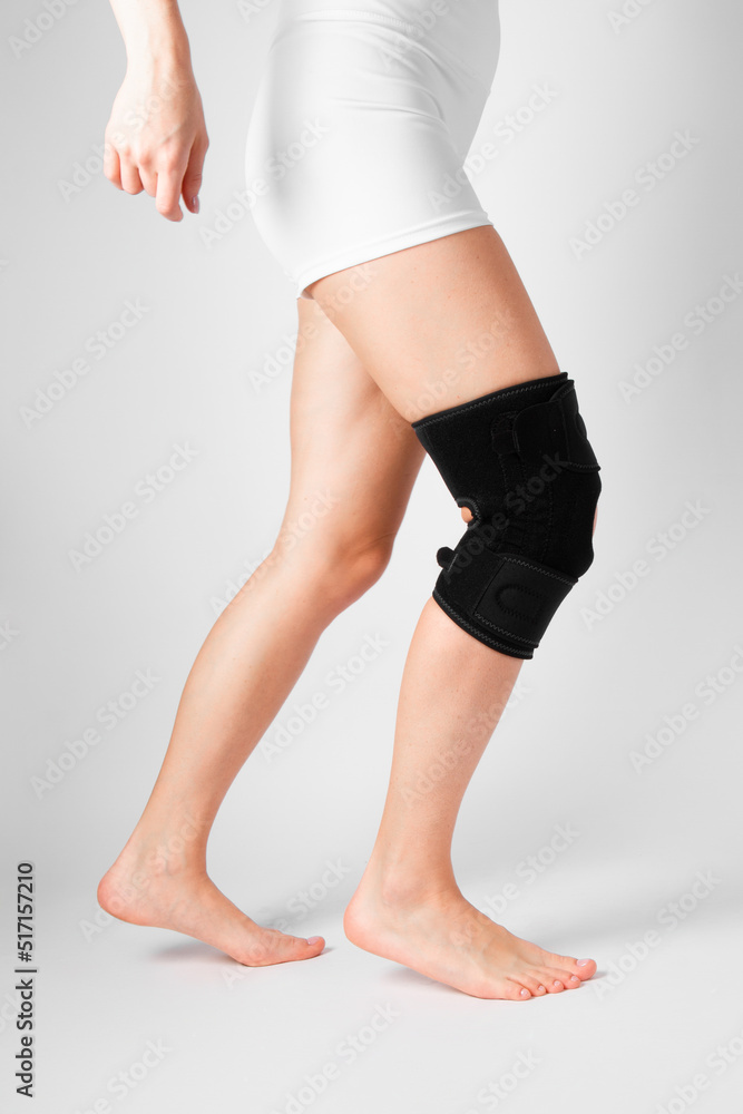 Knee Support Brace on leg isolated on white background. Elastic orthopedic orthosis. Anatomic braces for knee fixation, injuries and pain. Protective knee joint bandage sleeve. Trauma, rehabilitation. Knee Support Brace on leg isolated on white background. Elastic orthopedic orthosis. Anatomic braces for knee fixation, injuries and pain. Protective knee joint bandage sleeve. Trauma, rehabilitation.