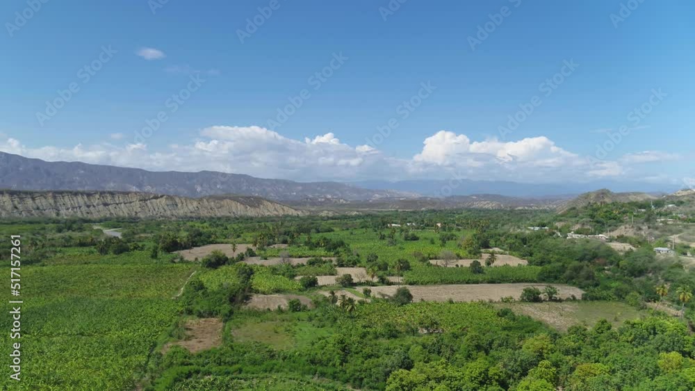Green fields with cultivated plants against the backdrop of a mountain landscape. Farmland in the mountains. Plant sprouts in the beds. Green fields with cultivated plants against the backdrop of a mountain landscape. Farmland in the mountains. Plant sprouts in the beds.