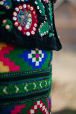 Part of Ukrainian traditional costume closeup: skirt with colorful ornament, velvet pot embroidered with flowers with sequins and beads. Culture of Ukraine	
