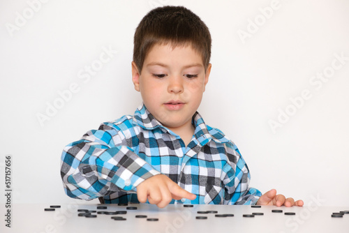 Bilde på lerret A 4-year-old boy is learning to count, teaching black numeracy chips for prescho