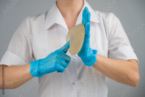 A plastic surgeon shows a breast silicone implant.