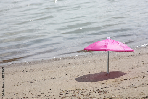 beach umbrella in sand on a beach near water © afrumgartz