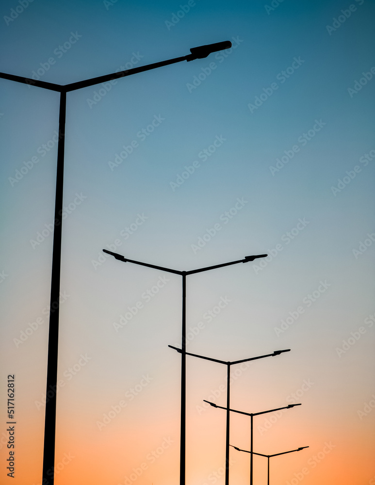 Street lights on highway against the backdrop of the sunset sky