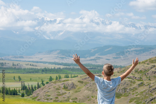 Little happy boy enjoys the view of the mountains. Empty space for text