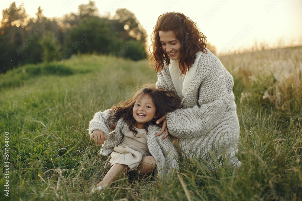 Fototapeta premium Mother with daughter playing in a summer field
