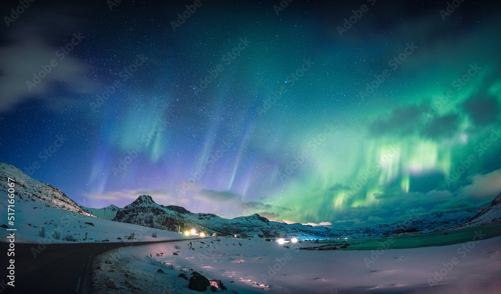 Beautiful Aurora borealis, Northern lights glowing over snow mountain and coastline in the night sky at Lofoten Islands