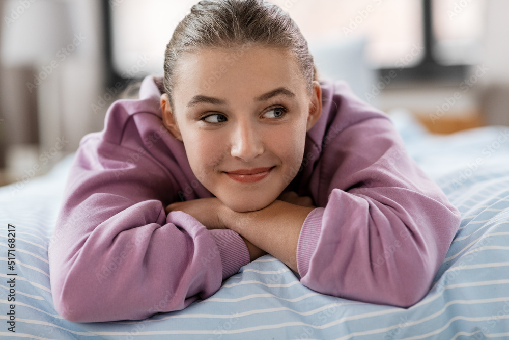 people concept - happy smiling girl lying on bed at home people concept - happy smiling girl lying on bed at home