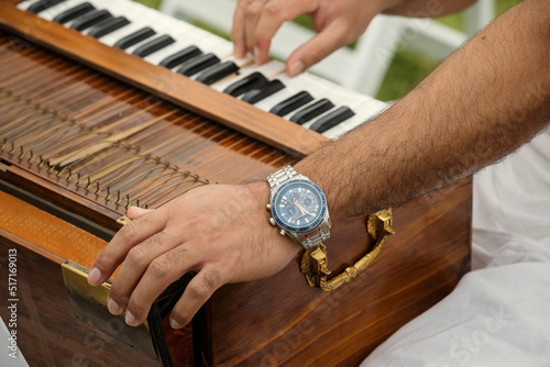 hands of Indian man playing the harmonium at an event outdoors photo