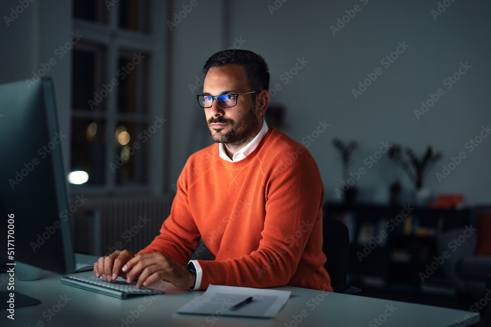 Focused businessman using a computer, working overtime at the office. Focused businessman using a computer, working overtime at the office.
