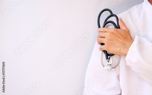 Doctor is holding a stethoscope and wearing a white coat.