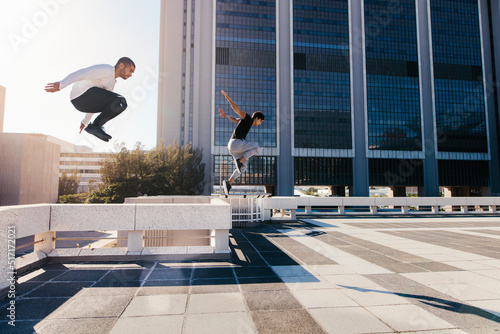 Fotografie Two sportsmen doing parkour in city