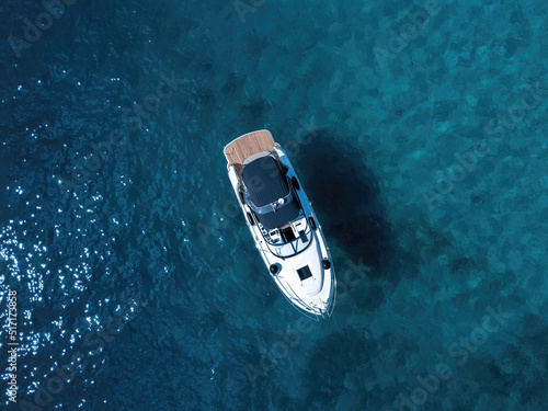 Boat from above floating in teal sea  © Julian