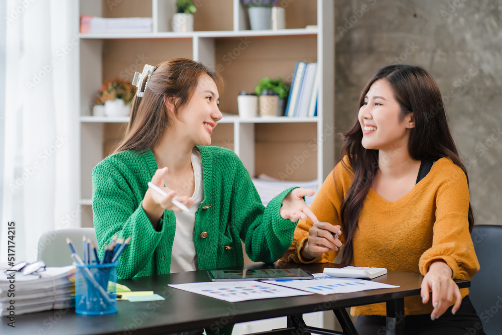Two beautiful young asian businesswoman working together using digital tablet at office Two beautiful young asian businesswoman working together using digital tablet at office