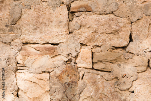 Masonry walls of natural sand color. Stone texture close-up, construction and mining background.