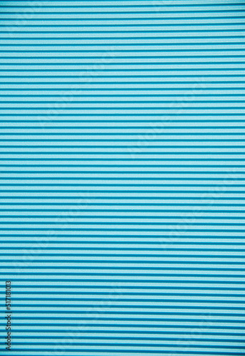 Abstract background made of corrugated paper for blue application. Space for text. Texture. Horizontal stripes.
