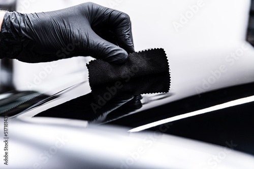 Obraz na płótnie Employee of a car wash or a car detailing studio applies a ceramic coating to the paintwork w salonie