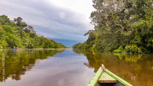 Puerto Narino, Columbia - Feb. 14, 2017: Boating on the Lago Tarapoto. Traveling with a canoe boat on the Amazon River in Latin America. Tropical forest surrounding the brown natural water background photo