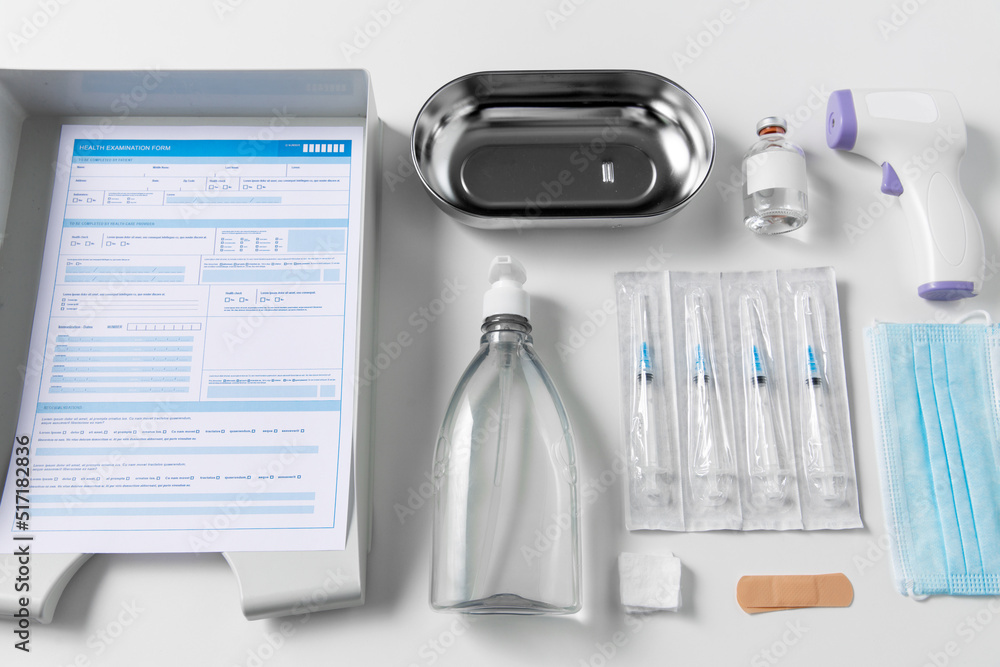 medicine and healthcare concept - close up of syringes, mask, hand sanitizer and other medical stuff on table at hospital medicine and healthcare concept - close up of syringes, mask, hand sanitizer and other medical stuff on table at hospital