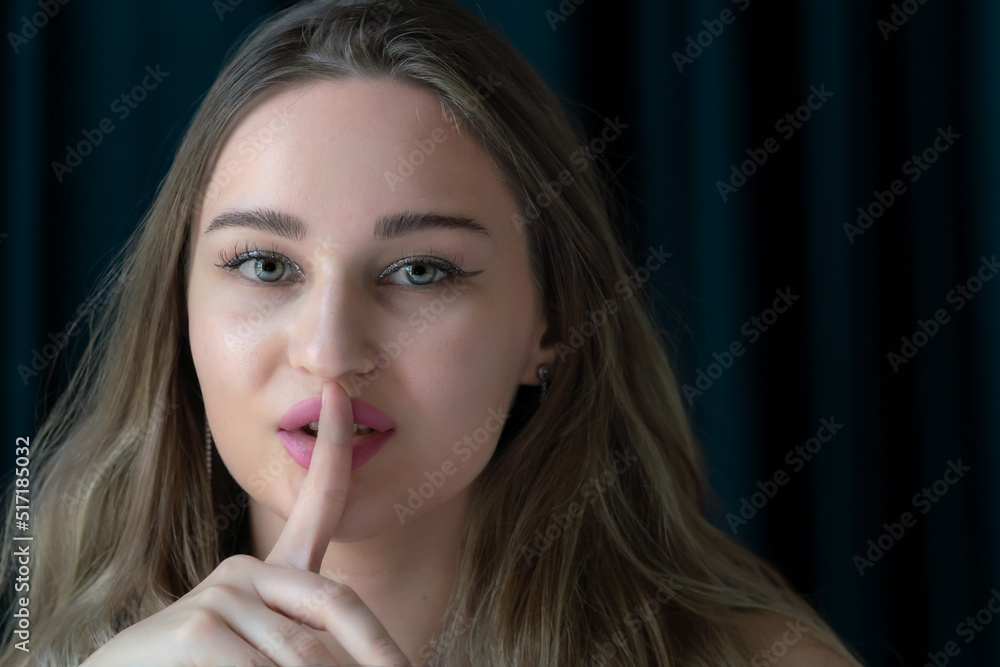 Young white woman with finger over her lips Young white woman with finger over her lips