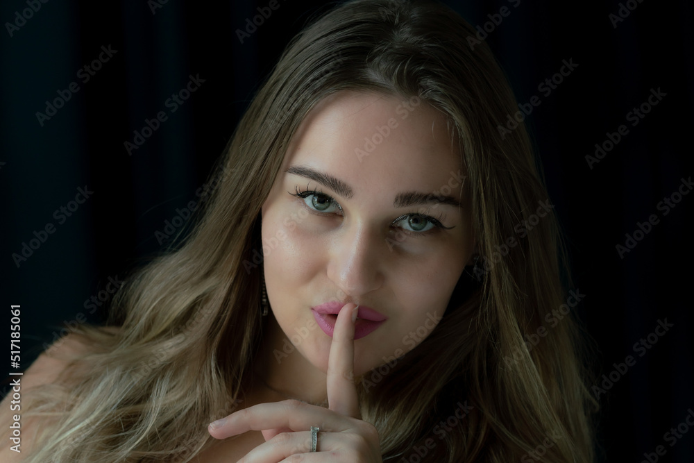 Young white woman with finger over her lips Young white woman with finger over her lips