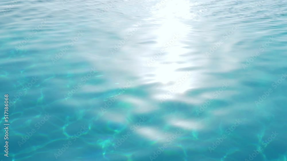 Water in Sunlight and Glare, Turquoise Blue Surface of Sea Ocean Pool in Sun Sunbeam, Slow Motion. Beautiful Natural Background. Water in Sunlight and Glare, Turquoise Blue Surface of Sea Ocean Pool in Sun Sunbeam, Slow Motion. Beautiful Natural Background.