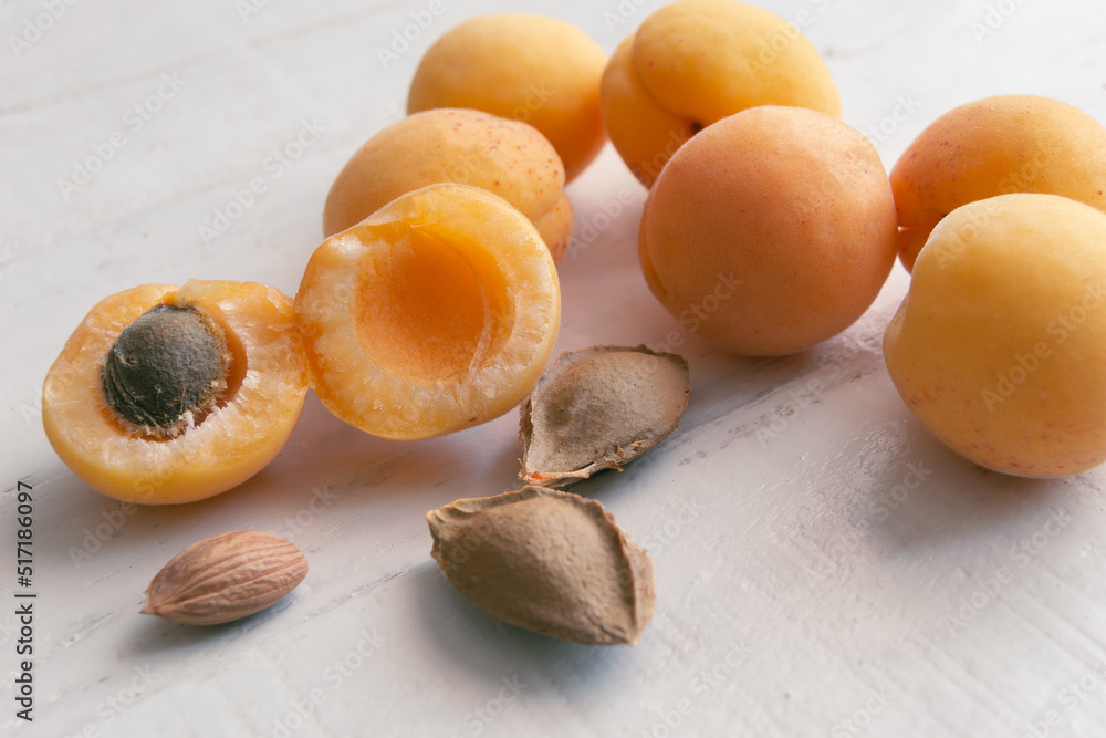 Apricots and kernel on white wooden background. Apricot seeds. Apricots and kernel on white wooden background. Apricot seeds.