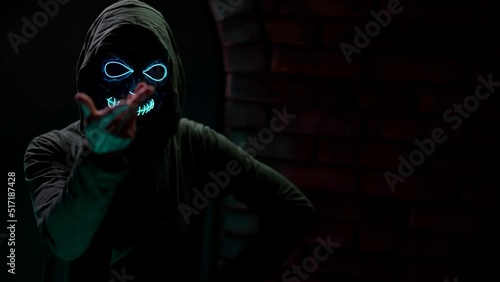 The creepy face of a witch woman is a mask of a mystical girl in a dark world. A gothic cruel woman with evil eyes.